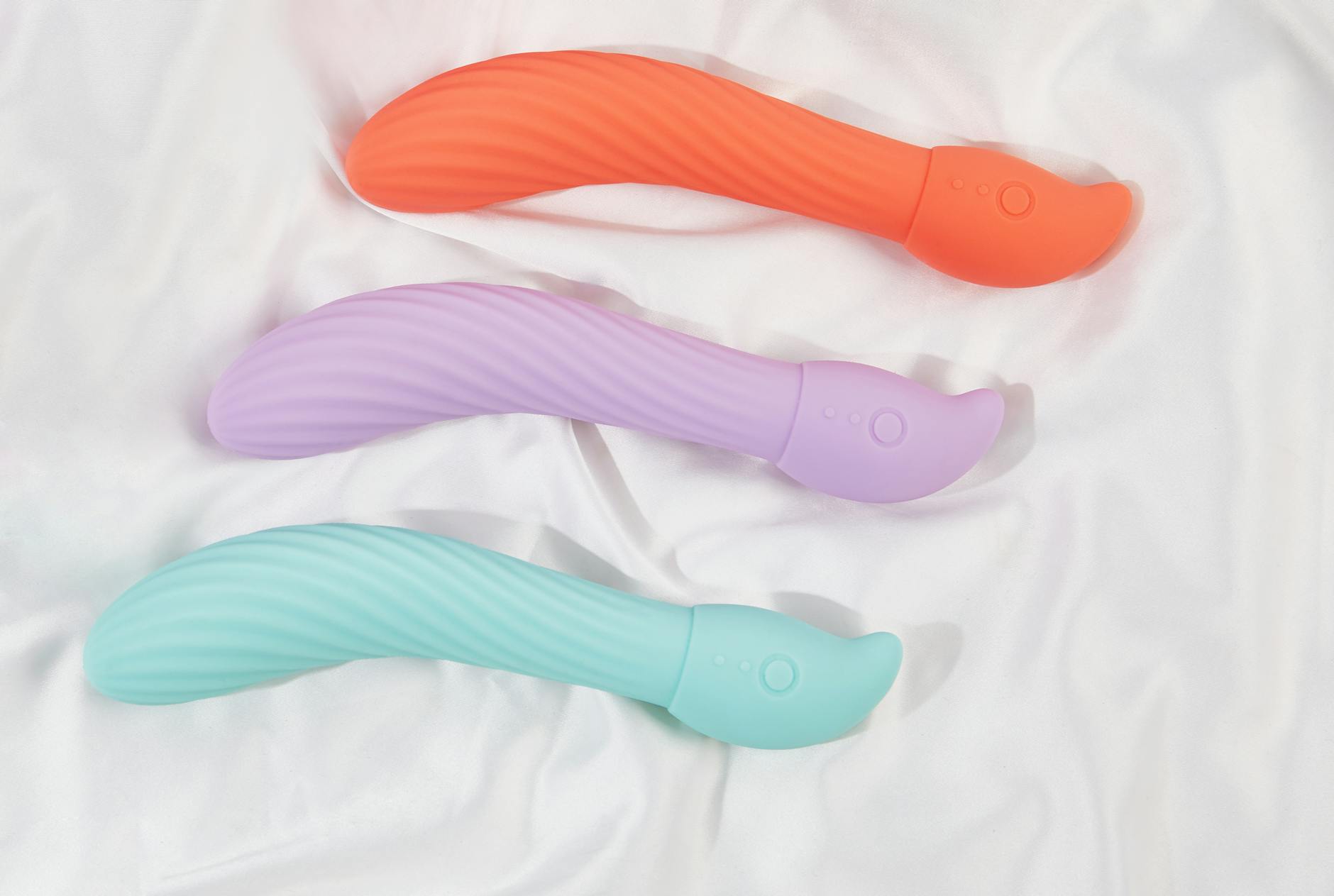 A stylish teal vibrator on smooth white silk fabric, perfect for adult lifestyle imagery.