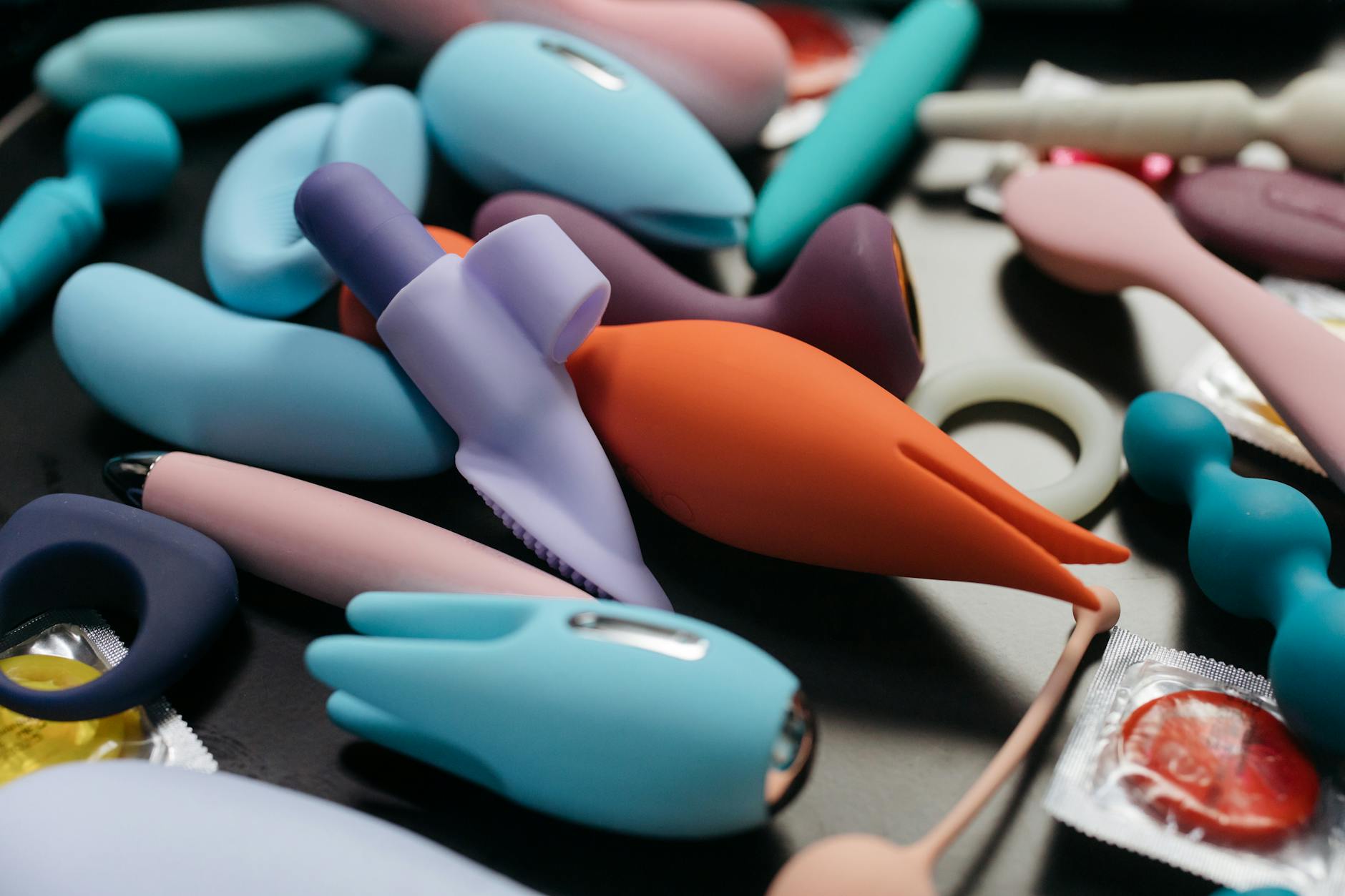 An array of vibrant adult toys including vibrators and rings displayed closely together.