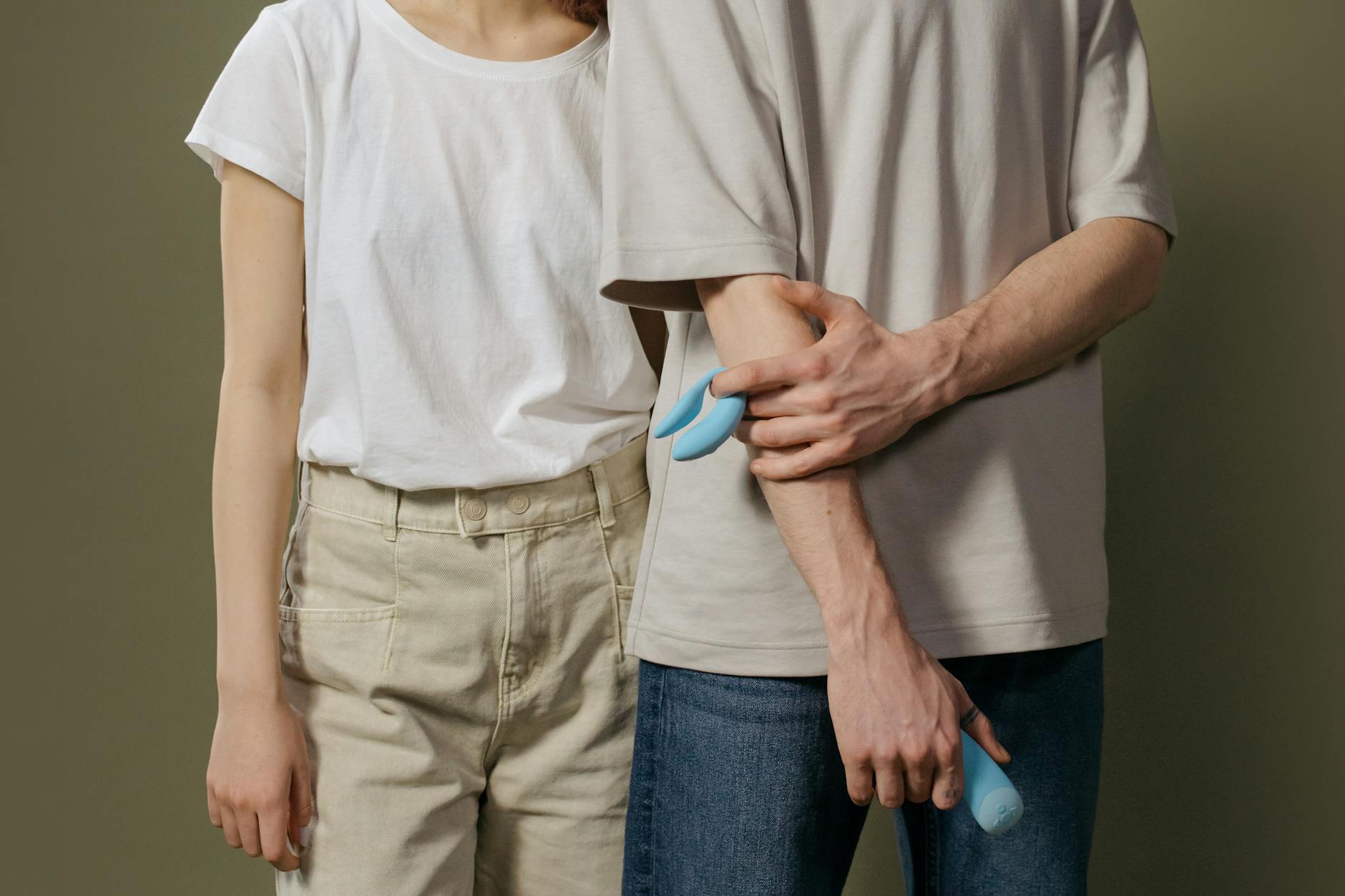 Hand holding a vibrator against a minimalistic backdrop, illustrating modern intimacy practices